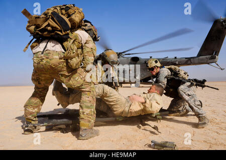 U.S. Air Force pararescuemen, 82nd Expeditionary Rescue Squadron (ERQS), and a U.S. Army Site Security Team soldier, 2nd Battalion, 138th Field Artillery Regiment, load a mock isolated person onto a stretcher during a training exercise in the Grand Bara Desert, Djibouti, Jan. 16, 2013. Airmen, Marines, soldiers and sailors from Combined Joint Task Force - Horn of Africa and members of the French Foreign Legion participated in the exercise in order to enhance interoperability during personnel recovery operations.  Airman 1st Class Nicholas Byers Stock Photo