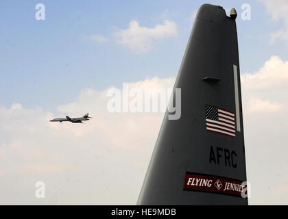 A B-1B Lancer flies past the tail of a C-130J Hercules during the 2013 Dubai Airshow at the Dubai World Central airport in Jebel Ali, United Arab Emirates, Nov. 20, 2013. The Lancer is assigned to the 9th Expeditionary Bomb Squadron deployed from Dyess Air Force Base, Texas. The United States participates in the Dubai Air Show to demonstrate a commitment to regional security, to demonstrate the flexibility of airpower, and to strengthen military-to-military relationships with regional partners.  Senior Airman Bahja J. Jones) Stock Photo