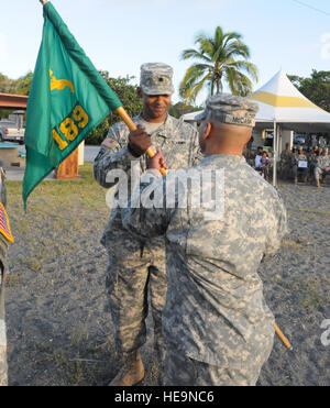 GUANTANAMO BAY, Cuba – 525th Military Police Battalion commander, Lt. Col. Christopher Wynder passes the guidon to 189th Military Police Company commander, Capt. Christopher McCann during the 189 Military Police Company change-of-command ceremony, Oct. 28, 2010. JTF Guantanamo provides safe, humane, legal and transparent care and custody of detainees, including those convicted by military commission and those ordered released by a court. The JTF conducts intelligence collection, analysis and dissemination for the protection of detainees and personnel working in JTF Guantanamo facilities and in Stock Photo