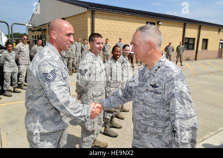 Maj. Gen. Rick Martin, U.S. Air Force Expeditionary Center commander, presents Tech. Sgt. Patrick Raible, 3d Aerial Port Squadron, with his coin after receiving a mission briefing about the 3d Aerial Port Squadron, during his tour of 43d Airlift Group units Sept. 16. Sgt. Raible overcame Air Force and Army communication challenges in order to establish the Global Air Transportation Execution System connectivity in the passenger sheds. This initiative ended an 8-year in-transit visibility issue and reduced passenger processing time by 80 percent.  (U.S. Air Force Photo/Marvin Krause) Stock Photo