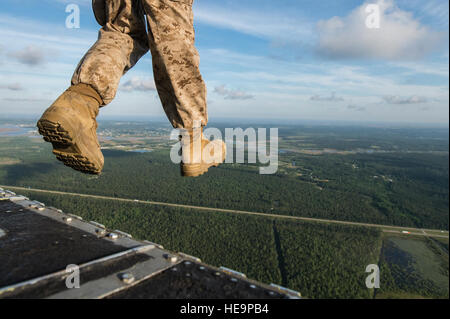 A U.S. Marine Corps paratrooper jumps from an Army CH-47 Chinook helicopter carrying Marines with the 4th Air and Naval Gunfire Liaison Company, the 3rd Force Reconnaissance Company and the 4th Reconnaissance Battalion over the John C. Stennis Space Center in Mississippi May 7, 2014, during Emerald Warrior 14. Emerald Warrior is a U.S. Special Operations Command-sponsored two-week joint/combined tactical exercise designed to provide realistic military training in an urban setting.  Senior Airman Jodi Martinez Stock Photo