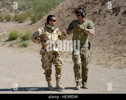 A member of the U.S. Army Special Forces, 3rd Special Forces Group, Fort Bragg, N.C., speaks with 1st Lt. Carlos Diaz, Colombian air force, Special Forces Group, during weapons tactical training, Exercise Angel Thunder, Tucson, Ariz., May 5, 2014. Angel Thunder is a multilateral annual exercise that supports the DoD's training requirements for personnel recovery responsibilities through high-fidelity exercises. AT provides the most realistic PR training environment available to USAF rescue forces as well as their joint, interagency and coalition partners.  Tech. Sgt. Bradley C. Church) Stock Photo