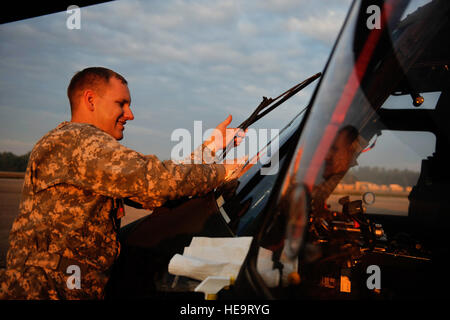 U.S. Army Sgt. Matthew Larsen, 7th Battalion, 158th Aviation Regiment, cleans the windows of a UH-60 Blackhawk while waiting on standby for a medical evacuation mission during Exercise Vibrant Response at Camp Atterbury, Ind., Aug. 21, 2011.  Vibrant Response is the largest chemical, biological, radiological and nuclear (CBRN) response exercise designed to prepare expeditionary units focused on responding to domestic CBRN incidents.  (U.S. Air Force Photo Staff Sgt. Eric Harris) Stock Photo