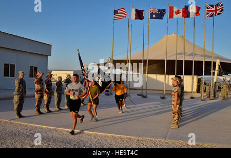 Service members from the U.S. Army, Marine Corps, Navy and Air Force complete the 24-hour prisoners of war and missing in action vigil run as U.S. military, coalition and mission partners render salutes at the 379th Air Expeditionary Wing in Southwest Asia, Sept. 21, 2013. The run began Sept. 20 and culminated with a closing ceremony and traditional flag folding by the base honor guard in reverence to those still missing. Staff Sgt. Benjamin W. Stratton) Stock Photo