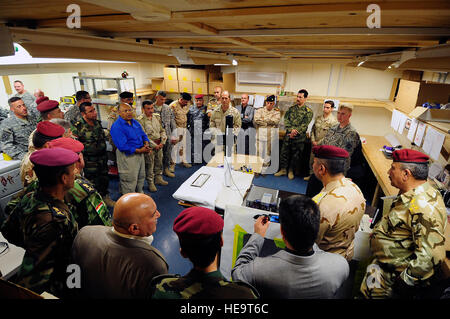 Key leaders of the Iraqi security forces, Kurdish Peshmerga and U.S.Army are briefed by Navy Explosive Ordinance Disposal  personnel during a counter improvised explosive device demonstration on Contingency Operating Base Speicher in northern Iraq, Oct. 6. The demonstration included a controlled detonation of an improvised explosive device and showed the techniques and equipment used by EOD personnel to secure, process and investigate blast sites by collection and analysis of key evidence pieces found post IED blast. Stock Photo