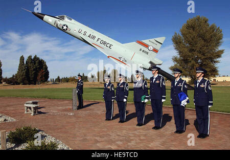 A US Air Force (USAF) Honor Guard Team assigned to the 141st Air Refueling Wing (ARW) Washington (WA) Air National Guard (ANG), prepares for a flag presentation, during a Memorial Ceremony honoring the crew of ESSO 77, and the spirit of fallen Guardsmen for the Unit’s history, held at Patriot Circle, Fairchild Air Force Base (AFB), WA. A mockup of an ANG F-102 Delta Dagger aircraft is visible in the background. Stock Photo