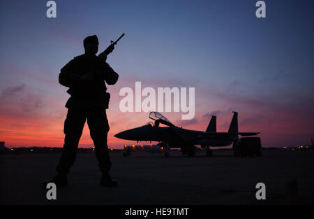 CAPE COD, Mass. -- Staff Sgt. Nassim Rizvi guards an F-15 Eagle on the flightline during a warm winter sunset here Dec. 23. Several members of the 102nd Fighter Wing are activated in support of Operation Noble Eagle.  Sergeant Rizvi is assigned to the 102nd Fighter Wing Security Forces.   Tech. Sgt. Sandra Niedzwiecki) Stock Photo