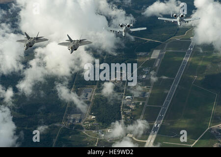 U.S. Air Force F-22 Raptors from the 95th Fighter Squadron, Tyndall Air Force Base, Fla., and A-10 Thunderbolt IIs from the 303rd Fighter Squadron part of the 442nd Fighter Wing, Whiteman Air Force Base, Mo., fly in formation over Amari Air Base, Estonia, Sept. 4, 2015. The U.S. Air Force has deployed four F-22 Raptors, one C-17 Globemaster III, approximately 60 Airmen and associated equipment to Spangdahlem Air Base, Germany. While these aircraft and Airmen are in Europe, they will conduct air training with other Europe-based aircraft. The United States is committed to ongoing reassurance eff Stock Photo