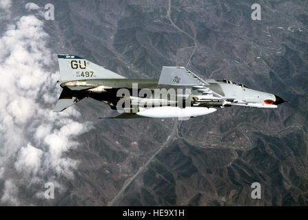 An air-to-air right underside view of a 497th Tactical Fighter Squadron F-4E Phantom II aircraft banking to the left during exercise Team Spirit '86.  The aircraft is armed with an AIM-9 Sidewinder missile. Stock Photo