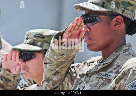 U.S. Army Spc. Shakira Lamb, from Stafford, Va., and U.S. Army Pfc. Stacey Jordan, from Belmont, N.Y., both military police officers with the 164th Military Police Company, 793rd Military Police Battalion, 3rd Maneuver Enhancement Brigade, render a tearful, final salute to the fallen soldiers from their company during a memorial ceremony June 11 on Forward Operating Base Mehtar Lam. Four military police officers from the 164th MP Company, U.S. Army Sgt. Christopher Bell, of Saint Joseph, Mich., U.S. Army Spc. Robert Voakes, Jr., of Hancock, Mich., U.S. Army Sgt. Joshua Powell of Tyler, Texas,  Stock Photo