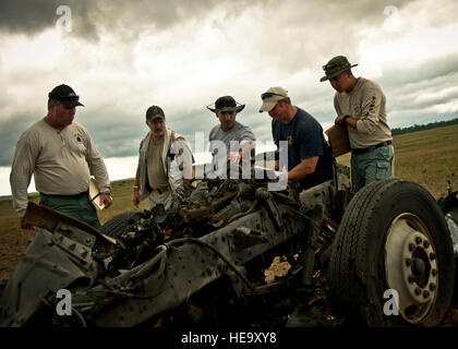 Capt. Thomas Bosco, a Florida State fire marshal, (middle) and other team members size up the blast scene and try to determine where the vehicle's identification number may be located Sept. 28 on the Eglin Air Force Base range. The investigation was part of the FBI's large vehicle post blast school attended by state and local law enforcement agencies as well as Navy and Air Force explosive ordnance disposal technicians. Three vehicles were blown up to create the crime scenes that students would investigate. The week-long course was the second held on Eglin with 67 students representing 18 diff Stock Photo