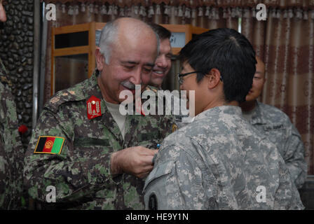 KABUL, Afghanistan -- Afghan Maj. Gen. Amin Ullah Karim, Commander, Afghan National Army Training Command, presents U.S. Army Staff Sgt. Jennifer Marcos, Afghan National Army Female Officer Candidate School instructor, with a U.S. Army Achievement Medal during an award ceremony, Sept. 22, 2010. Sergeant Marcos was recognized alongside her fellow U. S. and Afghan female instructors for the training of the first ANA Female Officer Candidate Schools class. Staff Sgt. Laura R. McFarlane Stock Photo