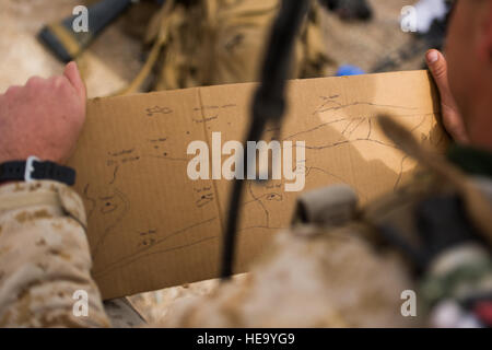 U.S. Marine Cpl. T. J. Cameron, artillery forward observer, 3rd Light Armored Reconnaissance Battalion, 1st Marine Division, observes his sketch of the surrounding land at Integrated Training Exercise 2-16 at Marine Corps Air Ground Combat Center, Twentynine Palms, Calif., Jan. 23, 2016. MCAGCC conducts relevant live-fire combined arms, urban operations, and joint/coalition level integration training that promote operational forces’ readiness.  Senior Airman Steven A. Ortiz Stock Photo