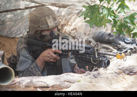 A U.S. Army Ranger student, assigned to the Airborne and Ranger Training Brigade, pulls security with an M4 assault rifle in a fighting position at a patrol base on Camp Rudder, Eglin Air Force Base, Fl., July 8, 2016. The Florida Phase of Ranger School is the third and final phase that these Ranger students must complete to earn the coveted Ranger Tab.  Sgt. Austin Berner Stock Photo