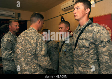 U.S. Air Force Senior Airman Daniel Smith, originally from Helena, Mont., and an electrician with the 777th Expeditionary Civil Engineer Squadron at Kandahar Airfield, receives an Army Achievement Medal from the 4-73rd Cavalry Battalion Commander, U.S. Army Lt. Col. Michael Wawrzyniak, on Jan. 24, Forward Operating Base Farah, Afghanistan. Smith (pictured in the center) and two plumbers from the 777th ECES, Staff Sgt. Destrey Robbins, originally from Madison, Neb., and Airman 1st Class Whitney Sargent, who hails from Tucson, Ariz., were each awarded an Army Achievement Medal for their work whi Stock Photo