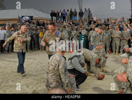 Terry Bradshaw (left) play quarterback during a football game with the troops while Howie Long tries to distract him from catching the ball Nov. 7. Jay Glazer, Terry Bradshaw, Jimmy Johnson, Curt Menefee, Howie Long, and Michael Strahan came to visit Bagram to boost morale.  The 'Fox NFL Sunday' team came to visit Bagram to boost morale.  They are scheduled to broadcast live Nov. 8 from Afghanistan. Stock Photo