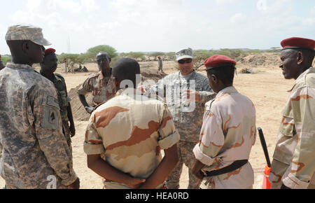 U.S. Army Sgt. 1st Class Ramon Perales, fifth from left, Kentucky National Guard's 2-138th Forward Support Company instructor assigned to Combined Joint Task Force-Horn of Africa, provides feedback to La Force Armée de Djibouti soldiers after an entry control point exercise at FAD Poste de Loyada, near the Somalia border April 11, 2013. Overall, the soldiers and the FAD spent two weeks sharing best ECP practices to help strengthen Djiboutian border security.  Staff Sgt. Caleb Pierce/released) Stock Photo