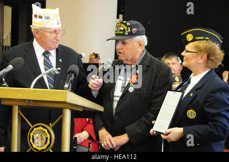 Larry Vetter, the North Dakota American Legion department commander, left, and Linda Wharley, the Fargo American Legion Post 2 commander, look on as Conrad 'Connie' Newgren speaks during an award ceremony Nov. 11 at the Gilbert C. Grafton Post 2 American Legion, Fargo, N.D. Newgren is being presented the French Legion of Honor Medal, which is the highest distinction that the nation of France has to offer, for 'valorous action' during World War II. Newgren served as a Private 1st Class in the 3rd Infantry Division, and is believed to be the last surviving service member to have served shoulder  Stock Photo