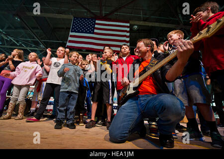 Bass guitarist, Emmy/Golden Globe-winning actor Gary Sinise and the Lt. Dan Band perform for children of U.S. Coast Guardsmen in a helicopter maintenance hanger June 25, 2012 at Coast Guard Air Station Kodiak, Alaska. Sinise and the Lt. Dan Band are in Alaska on a three stop tour to perform for military service members and their families the Lt. Dan Band have performed numerous concerts around the world to show their support to members of the U.S. military. ( U.S. Air Force Tech. Sgt. Michael R. Holzworth Stock Photo