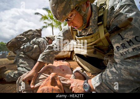 U.S. Army Staff Sgt. Tony Gonzalez and Staff Sgt. Joseph Lollino, combat medics assigned to Bravo Company, Tripler Army Medical Center, treat a simulated casualty during a combat trauma evaluation as part of the 2012 Pacific Regional Medical Command Best Medic Competition Aug. 28, 2012, at Schofield Barracks, in Wahiawa, Hawaii.  The PRMC Best Medic competition is a 72-hour physical and mental test of U.S. Army Medics leadership, teamwork, tactics medical knowledge and warrior tasks. The winners of the PRMC competition move on to compete for the ArmyÕs Best Medic at Ft. Sam Houston in San Anto Stock Photo