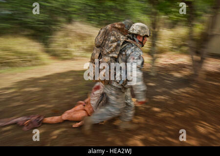 U.S. Army Staff Sgt. Tony Gonzalez and Staff Sgt. Joseph Lollino, combat medics assigned to Bravo Company, Tripler Army Medical Center, move a simulated casualty to safety during a combat trauma evaluation as part of the 2012 Pacific Regional Medical Command Best Medic Competition Aug. 28, 2012, at Schofield Barracks, in Wahiawa, Hawaii.  The PRMC Best Medic competition is a 72-hour physical and mental test of U.S. Army Medics leadership, teamwork, tactics medical knowledge and warrior tasks. The winners of the PRMC competition move on to compete for the ArmyÕs Best Medic at Ft. Sam Houston in Stock Photo