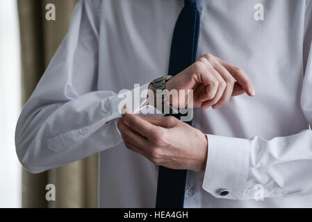 man in a tux fixing his cufflink Stock Photo