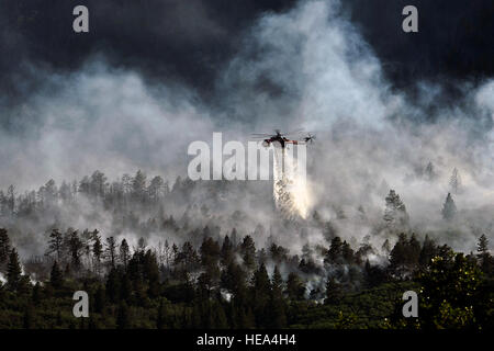 A helicopter drops water on the fire as firefighters continued to battle the blaze that burned into the evening hours in Waldo Canyon on the U.S. Air Force Academy June 27, 2012. The fires, which have burned more than 15,000 acres, began spreading to the southwestern corner of the Academy in the early morning, causing base officials to evacuate residents. Officials estimated that the fire had spread to about 10 acres of land belonging to the Academy. Currently, more than 90 firefighters from the Academy, along with assets from Air Force Space Command; F.E. Warren Air Force Base, Wyo.; Fort Car Stock Photo