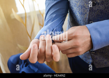 man in a tux fixing his cufflink Stock Photo