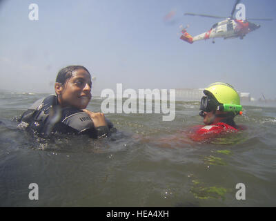 U.S. Air Force Staff Sgt. Vanessa Goris, left, prepares to be hoisted into an HH-60J Jayhawk helicopter with the help of Coast Guard Aviation Survival Technician 3rd Class Michael Linehan Aug. 25, 2009, during water survival training at Langley Air Force Base, Va. Members of the Coast Guard and the Hampton Police Department assisted with the training, which teaches students how to survive if they egress over water. Goris is the noncommissioned officer-in-charge of the 1st Aerospace Medicine Squadron?s human performance training team.  Senior Airman Zachary Wolf, U.S. Air Force Stock Photo