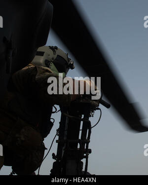 An aerial gunner with the 303rd Expeditionary Rescue Squadron looks out from his position in an HH-60 Pave Hawk during emergency procedures and daytime tactical flight maneuvers training prior to takeoff from Camp Lemonnier, Djibouti, July 10, 2015. The 303rd ERQS conducts training flights to maintain proficiency and provide full mission capability to users while deployed in support of humanitarian aid and contingency operations in the Combined Joint Task Force Horn of Africa area of responsibility. ( Staff Sgt. Gregory Brook/ Released. This image has been cropped to emphasize the subject) Stock Photo