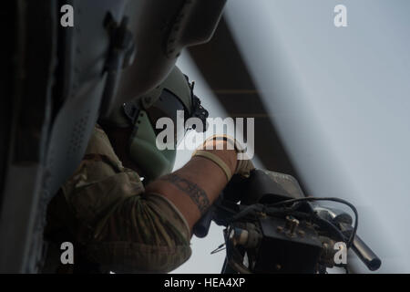 An aerial gunner with the 303rd Expeditionary Rescue Squadron looks out from his position in an HH-60 Pave Hawk during emergency procedures and daytime tactical flight maneuvers training after taking off from Camp Lemonnier, Djibouti, July 10, 2015. The 303rd ERQS conducts training flights to maintain proficiency and provide full mission capability to users while deployed in support of humanitarian aid and contingency operations in the Combined Joint Task Force Horn of Africa area of responsibility. ( Staff Sgt. Gregory Brook/ Released) Stock Photo