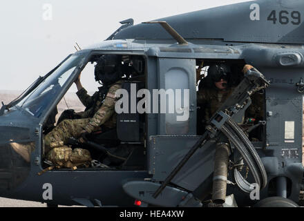 A pilot and an aerial gunner with the 303rd Expeditionary Rescue Squadron look out from their positions in an HH-60 Pave Hawk while in flight during emergency procedures and daytime tactical flight maneuvers training after taking off from Camp Lemonnier, Djibouti, July 10, 2015. The 303rd ERQS conducts training flights to maintain proficiency and provide full mission capability to users while deployed in support of humanitarian aid and contingency operations in the Combined Joint Task Force Horn of Africa area of responsibility. ( Staff Sgt. Gregory Brook/ Released) Stock Photo