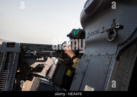 An aerial gunner with the 303rd Expeditionary Rescue Squadron looks out from his position in an HH-60 Pave Hawk during emergency procedures and daytime tactical flight maneuvers training over the training range after taking off from Camp Lemonnier, Djibouti, July 10, 2015. The 303rd ERQS conducts training flights to maintain proficiency and provide full mission capability to users while deployed in support of humanitarian aid and contingency operations in the Combined Joint Task Force Horn of Africa area of responsibility. ( Staff Sgt. Gregory Brook/ Released) Stock Photo