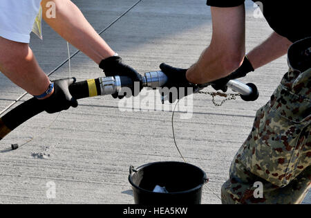 German air force civilians Paul Klein and Wolfgang Eupin remove a nozzle before refueling an USAFE C-21 during the setup of the ILA 2012 Berlin Air Show here Sept. 10.  ILA 2012 is expected to show about 300 aircraft from about 50 different countries. ILA 2012 is an international event hosted by Germany and more than 50 U.S. military personnel from bases in Europe and the United States are here to support the various U.S. military aircraft and equipment on display. The U.S. aircraft featured at ILA 2012 are the UH-60 Black Hawk, UH-72A Lakota, F-16C Fighting Falcon, C-17 Globemaster III, and C Stock Photo