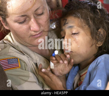 U.S. Army Sgt. Kornelia Rachwal comforts a young Pakistani girl being flown from Muzaffarabad to Islamabad, Pakistan aboard a U.S. Army CH-47 'Chinhook', 19 Oct, 2005.    The United States government is participating in a multinational humanitarian assistance and support effort lead by the Pakistani Government to bring aid to victims of the devastating earthquake that struck the region Oct. 8 2005.   Tech. Sgt. Mike Buytas) (Released) Stock Photo