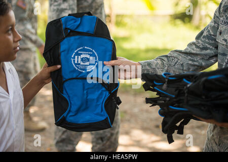 U.S. Air Force Lt. Col. Ryan Elliott, 823rd RED HORSE Squadron commander and New Horizons Honduras exercise commander, out of Hurlburt Field, Fla., and a native of Grove City, Pa., hands out donated backpacks to school children at the 23 of April school in Brisas del Mar, Honduras, July 21, 2015. The aid was provided by multiple donors and the event was organized by the New Horizons Honduras 2015 training exercise’s civil affairs team from the U.S. Army’s 81st Civil Affairs Battalion out of Fort Hood, Texas. New Horizons was launched in the 1980s and is an annual joint humanitarian assistance  Stock Photo