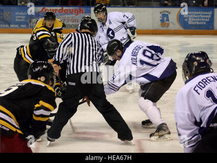 U.S. Air Force Senior Airman Alex Kolnberger, an Iceman hockey team forward assigned to the 354th Civil Engineer Squadron, battles for the puck during a faceoff at the 20th anniversary of the Commanders' Cup hockey game at the Carlson Center in Fairbanks, Alaska, Dec. 12, 2014. The Iceman hockey team, composed of active-duty and Air National Guard Airmen, defeated the Interior Alaska Army team 5-1, breaking the tie in the series while extending its win streak to three.  Master Sgt. Karen J. Tomasik Stock Photo