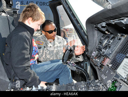 Army Sgt. Antonio Gattis, Charlie Company 1-214 Aviation Regiment flight medic, Landstuhl, Germany, shows the cockpit of a UH-60 Black Hawk to a child at the Berlin Air Show, commonly known as ILA 2012, here Sept. 14, 2012. More than 50 different countries have commercial and military aircraft on display at ILA 2012. The air show also features the U.S. Army UH-72A Lakota, and the U.S. Air Force F-16C Fighting Falcon, C-17 Globemaster III and C-130 Hercules. Stock Photo