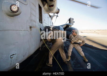 U.S. Marine Corps Cpl. Cole Bennick, crew chief, Marine Heavy Helicopter Squadron (HMH) 462, Marine Corps Station Miramar, Calif., and Lance Cpl. Eric Bacerna, bulk fuel specialist, Marine Wing Support Squadron 371, Marine Corps Air Station Yuma, Ariz., pressure refuel a CH-53E Super Stallion helicopter in support of Integrated Training Exercise 2-15 at Marine Corps Air Ground Combat Center Twentynine Palms (MCAGCC), Calif., Feb. 7, 2015. MCAGCC conducts relevant live-fire combined arms training, urban operations, and Joint/Coalition level integration training that promotes operational forces  Stock Photo