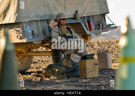 U.S. Marine Corps Corporal David Delon, assigned to Alpha Battery, 1st Battalion, 12th Marine Regiment, 3rd Marine Division, from Marine Corps Base Hawaii, waits for a fire mission to begin in support of Integrated Training Exercise 2-15 at Marine Corps Air Ground Combat Center Twentynine Palms (MCAGCC), Calif., Feb. 9, 2015. MCAGCC conducts relevant live-fire combined arms training, urban operations and joint/coalition level integration training that promotes operational forces readiness.  Staff Sgt. Amy F. Picard Stock Photo