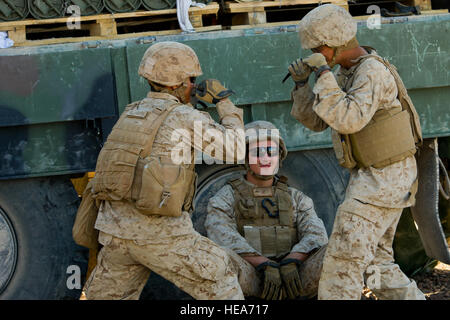 U.S. Marines assigned to Alpha Battery, 1st Battalion, 12th Marine Regiment, 3rd Marine Division, III Marine Expeditionary Force attached to 3rd Marine Regiment Force stationed out of Marine Corps Base Hawaii, joke around before for a fire mission in support of Integrated Training Exercise 2-15 at Marine Corps Air Ground Combat Center Twentynine Palms (MCAGCC), Calif., Feb. 9, 2015. MCAGCC conducts relevant live-fire combined arms training, urban operations and joint/coalition level integration training that promotes operational forces readiness.  Staff Sgt. Amy F. Picard Stock Photo