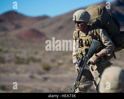 U.S. Marine Lance Cpl. Austin Ferris, Rifleman assigned to Bravo Company, 1st Battalion, 4th Marine Regiment, carries his M16 rifle and the Improved Load Bearing Equipment rucksack after a live fire event during Integrated Training Exercise 2-15 at Marine Corps Air Ground Combat Center (MCAGCC) Twentynine Palms Calif., Feb. 10, 2015. MCAGCC conducts relevant live-fire combined arms training, urban operations, and Joint/Coalition level integration training that promote operational forces readiness.  Staff Sgt. Kyle Brasier Stock Photo