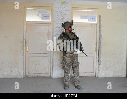 Texas Army National Guard Staff Sgt. Jozef Retana, 2nd Platoon, Company A, 1st Battalion, 143rd Infantry Regiment, security forces team leader, stands guard at a local Afghan school in Khawja Omari district as provincial reconstruction team engineers inspect construction of a new addition April 9,2012. The 37-member SECFOR's training began in July 2011 and their professionalism provides the highest level of security to PRT Ghazni. Stock Photo