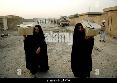 Iraqi women walk off after receiving boxes  of food from Iraqi soldiers during a combined humanitarian aid mission in Muhalla 456 of Ghazaliyah, Iraq on Sep. 6, 2008. The U.S. Soldiers are part of 2nd Platoon, Charlie Company,1st Squadron, 75th Cavalry, 101st Airborne Division and the Iraqi soldiers are part of Alpha Company, 22nd Battalion, 6th Iraqi Army Division.  Staff Sgt. Manuel J. Martinez Stock Photo