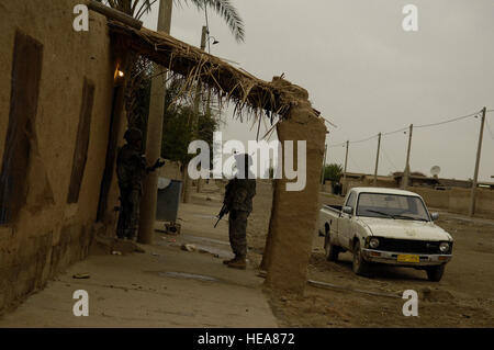 U.S. Army Soldiers provide security as Iraqi policemen search a house for items of interest during an Iraqi police led mission by the Emergency Services Unit April 1. Soldiers are assigned to Alpha Company, 2nd Battalion, 25th Infantry Division, Schofield Barracks, Hawaii.  Master Sgt. Andy Dunaway) Stock Photo