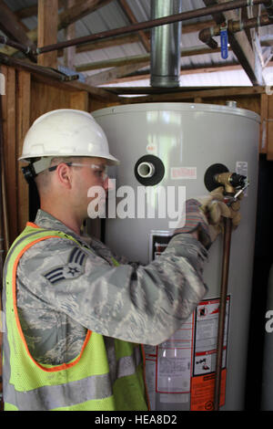 Senior Airman Derek Reeves tightens a fitting on a new hot water tank installed at Camp Hind Boy Scout Camp, Raymond, Maine, May 20, 2014. Reeves is a member of the 127th Civil Engineer Squadron, based at Selfridge Air National Guard Base, Mich. The Airmen, along with Marine Corps Reservists and Army Reservists, are working on various construction projects at the camp during an Innovative Readiness Training mission, which allows military personnel to get training in various tasks and a community organization, in this case the Boy Scouts, to benefit from the work.  Technical Sgt. Dan Heaton) Stock Photo