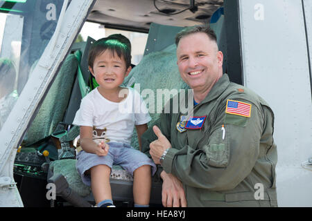 Maj. Destry Hill, UH-1N Iroquois pilot and 5th Air Force assistant director of operation, poses for photos with a local boy at Yokota Air Base, Japan, during the Japanese-American Friendship Festival Sept. 6, 2014. The festival is designed to bolster the bilateral relationship shared by the U.S. and Japan.  Osakabe Yasuo Stock Photo