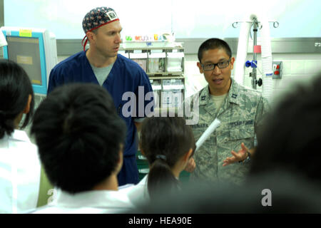 Right, Capt. Evan Masunaga, 374th Dental Squadron, translates information briefed by Maj. Jason Bolt, 374th Medical Surgical Operations Squadron, July 11, 2013, at Yokota Air Base, Japan. Students from the National Defense Medical College visited the 374th Medical Group to learn about hospital operations at Yokota.  Senior Airman Desiree Economides) Stock Photo