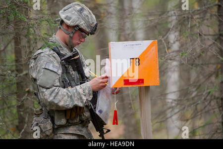 Pvt. Max Fogel, a native of Kansas City, Mo., assigned to Able Company, 3rd Battalion (Airborne), 509th Infantry Regiment, 4th Infantry Brigade Combat Team (Airborne), 25th Infantry Division, U.S. Army Alaska, calculates his next move on the land navigation course during Expert Infantryman Badge qualification on Joint Base Elmendorf-Richardson, Tuesday, Sept. 9, 2014. The Expert Infantryman Badge was approved by the Secretary of War on Oct. 7, 1943, and is currently awarded to U.S. Army personnel who hold infantry or Special Forces military occupational specialties and successfully pass the ri Stock Photo