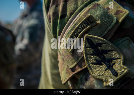 A Soldier assigned to the 1/10th Special Forces Group wears a patch on his uniform at Alzey drop zone near Kaiserslautern, Germany, Aug. 31, 2015. More than 20 Air Force independent duty medical technicians, security forces members and Army Special Forces paratroopers descended from a C-130J Super Hercules to quickly respond to a simulated medical emergency. Senior Airman Nicole Sikorski) Stock Photo